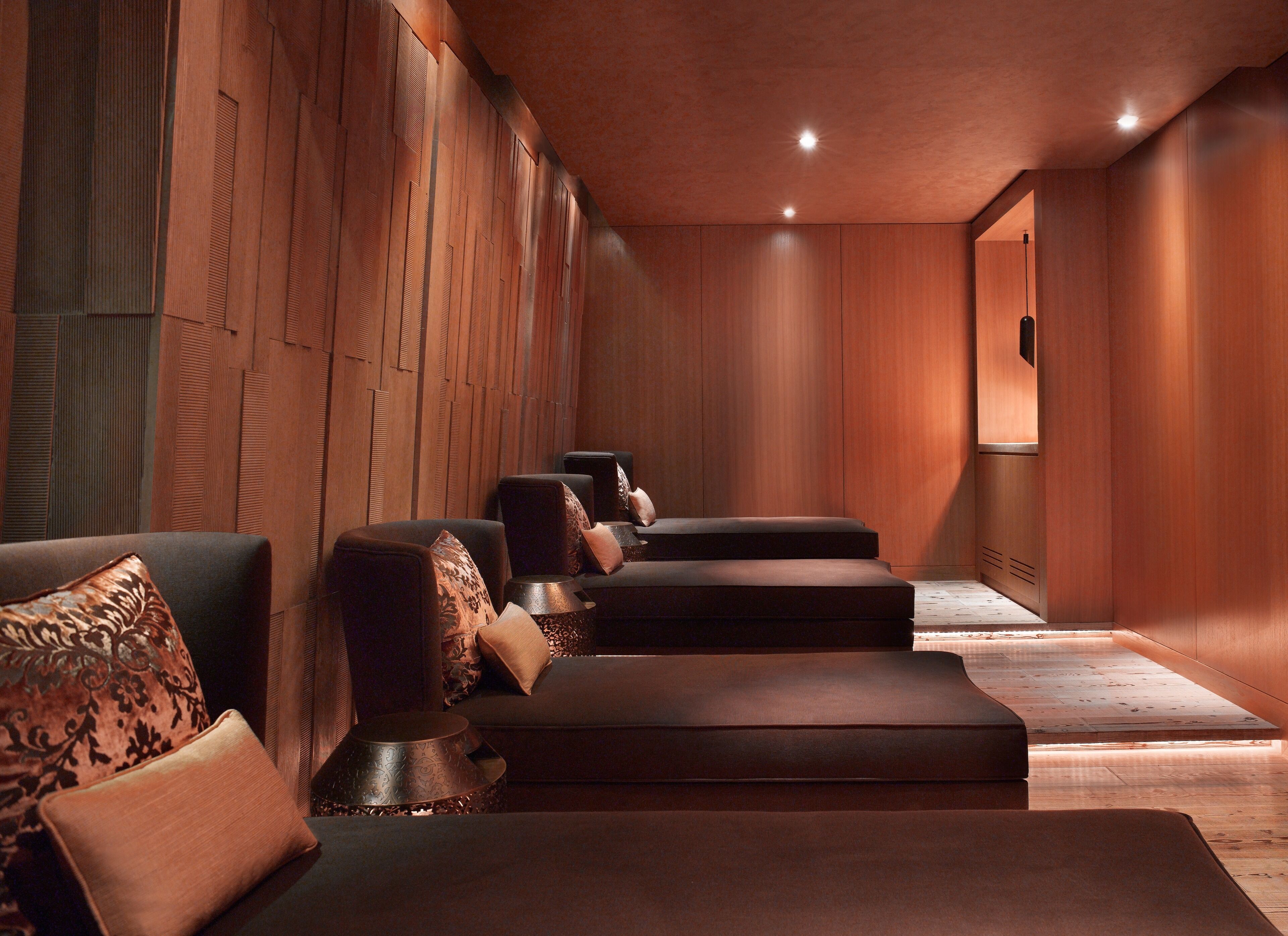 A spa room with wooden paneling, a reception desk, and seating areas.