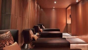 A spa room with wooden paneling, a reception desk, and seating areas.