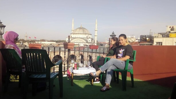 A terrace with outdoor seating, a view of a mosque, and a clear sky. - Sipahi (Istanbul)