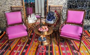A room with two wooden chairs with pink upholstery, a brass table with a decorative centerpiece, and a patterned carpet. - Sipahi (Istanbul)