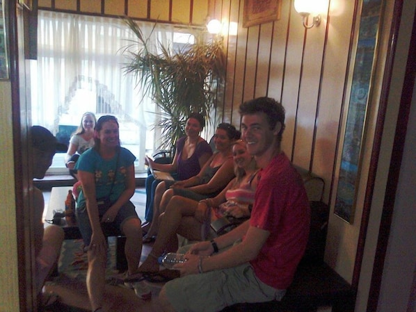 A group of people seated in a room with wooden walls and a large plant. - Sipahi (Istanbul)