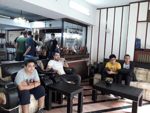 A hotel lobby with seating areas, a reception desk, and a decorative wall with flags. - Sipahi (Istanbul)