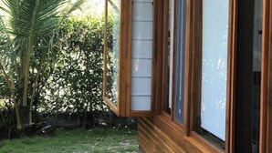 Una casa de madera con ventanas amplias y un porche cubierto.