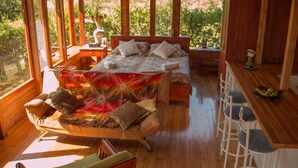 Un dormitorio de cabaña de madera con una cama, un escritorio y una silla.