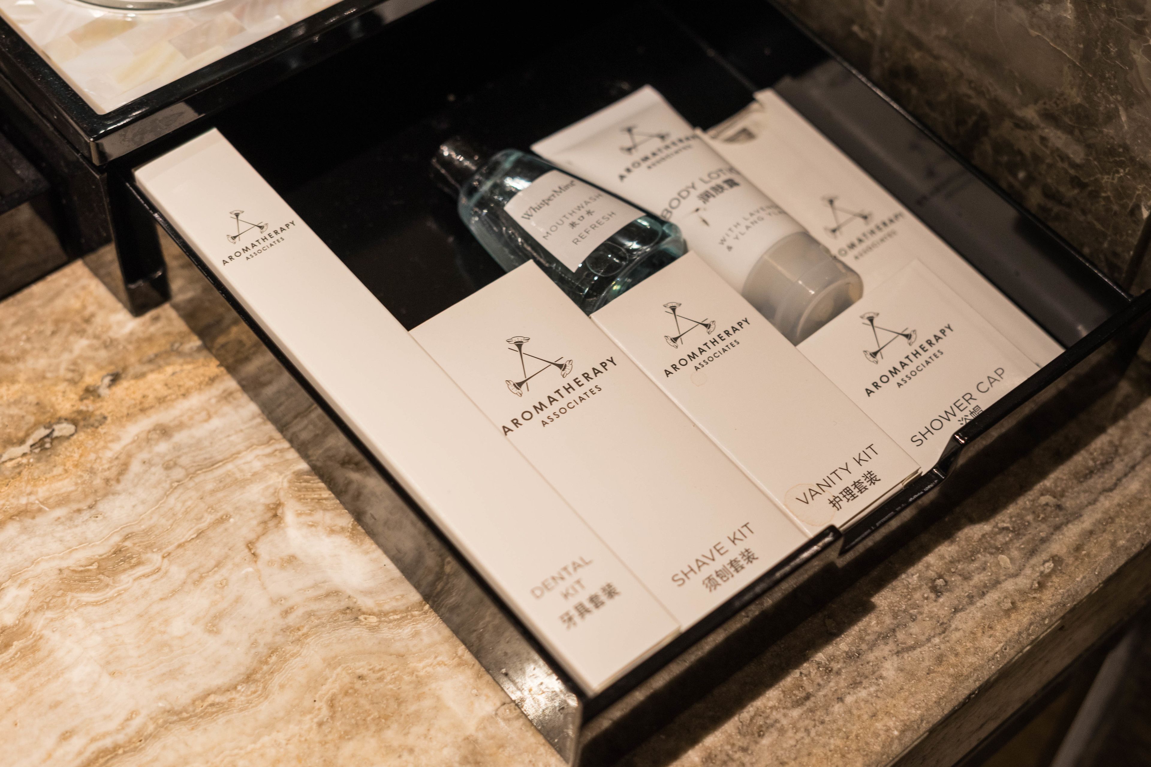 Une boîte contenant divers produits d’aromathérapie, notamment une trousse de soins dentaires, une trousse de rasage, une trousse de produits de beauté et un bonnet de douche.