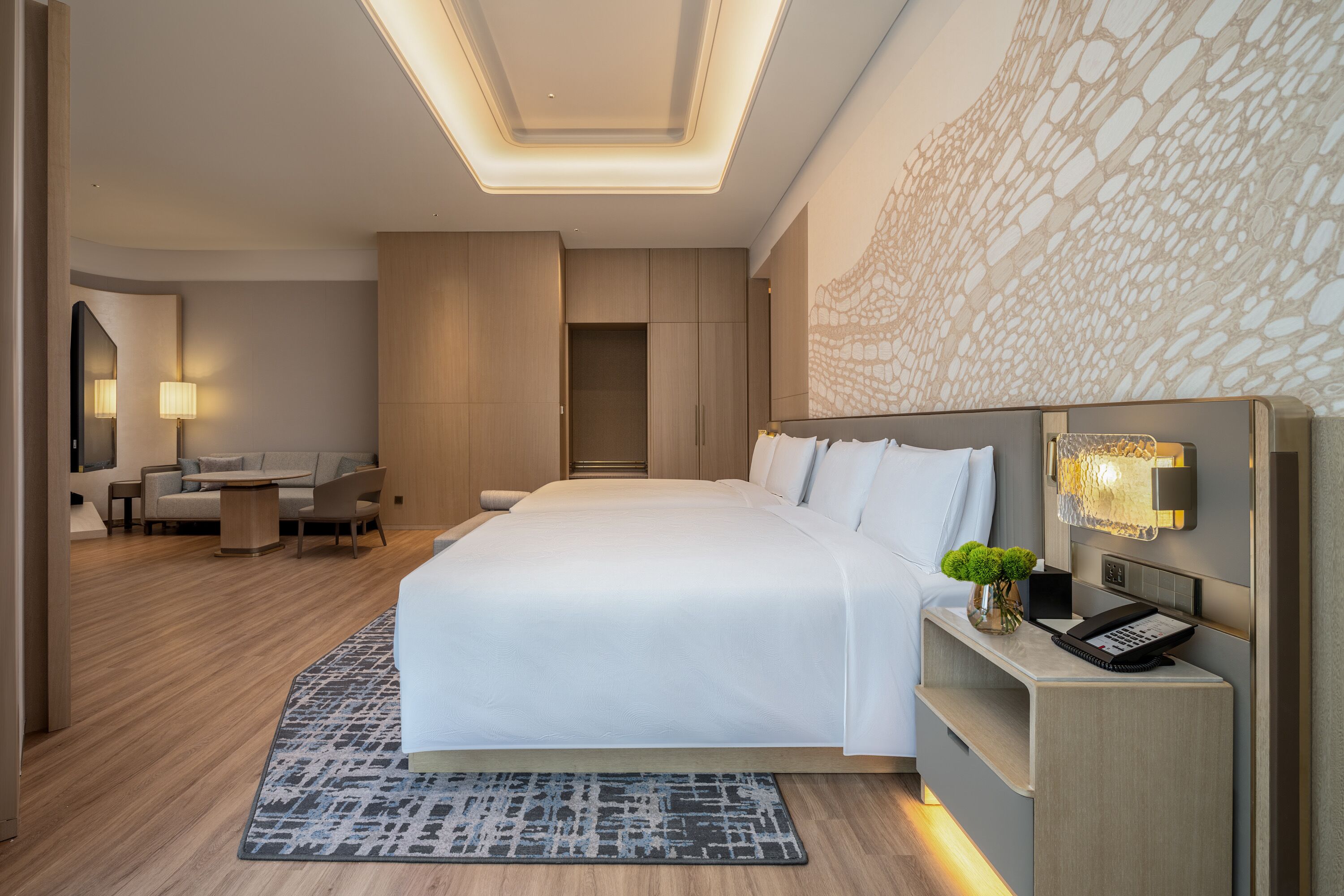 Una habitación de hotel moderna con una cama grande, un escritorio y una zona de estar.