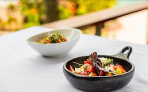 Dos platos de comida sobre una mesa, con un fondo desenfocado al aire libre.