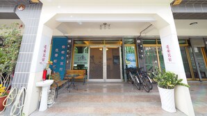 The exterior of a hotel with a signboard displaying the name and contact number. - Huadong Homestay (Taitung)