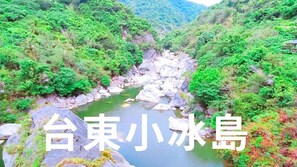 A river flowing through a lush green valley with rocky terrain and dense vegetation. - Huadong Homestay (Taitung)