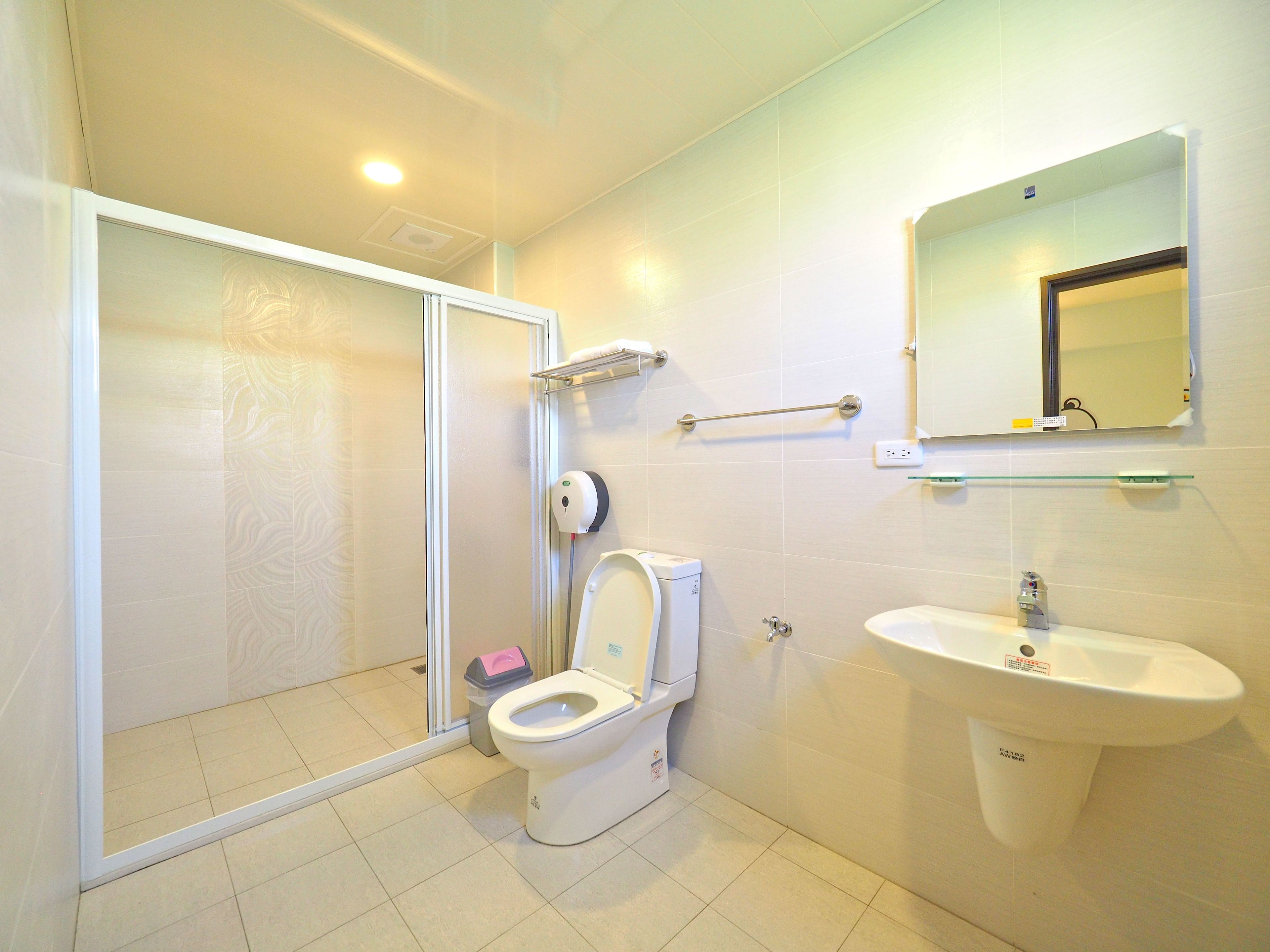 A bathroom with a toilet, sink, and shower area.