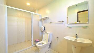 A bathroom with a toilet, sink, and shower area.