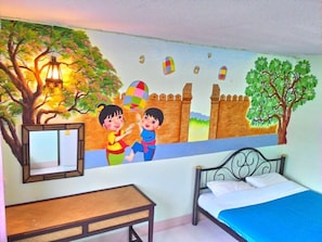 Una cameretta con un murale, un letto, un comodino e una finestra.