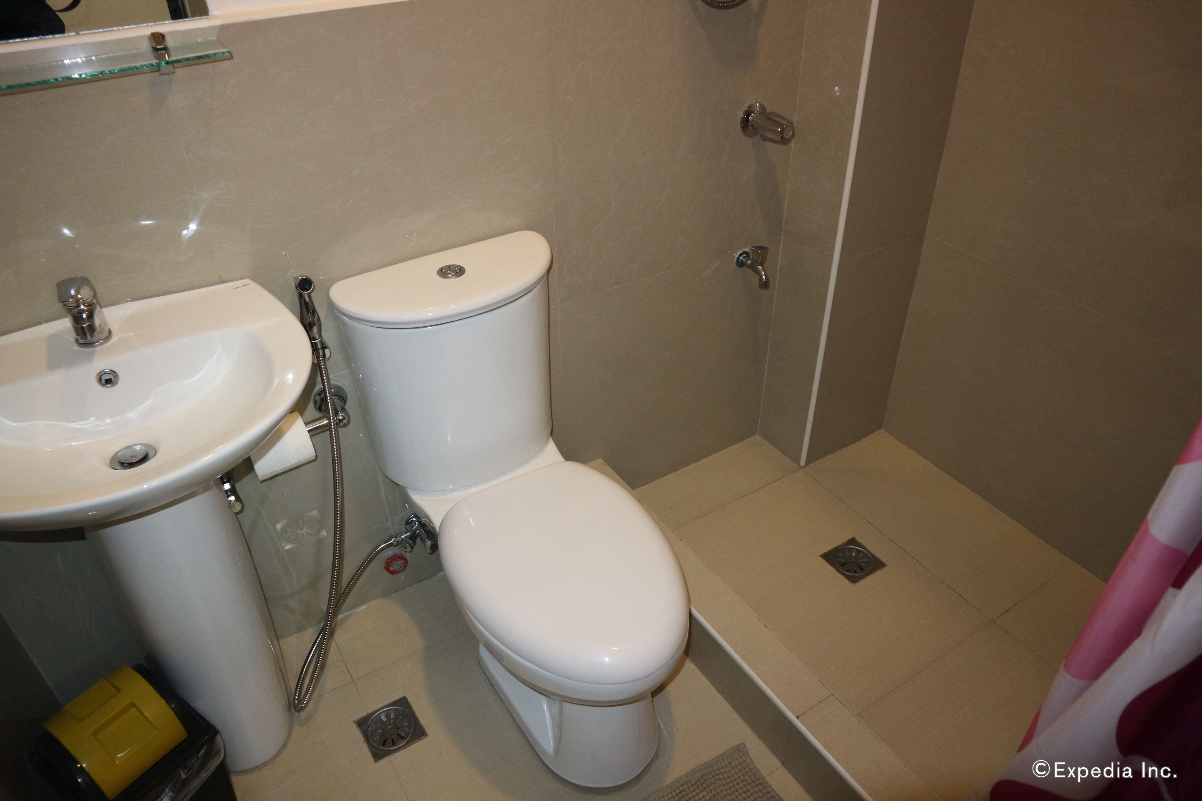 A bathroom with a toilet, sink, and shower.