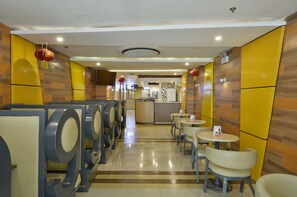 A public restroom with multiple urinals, a counter, and seating areas. - Hotel 99 Monumento Caloocan (Caloocan)