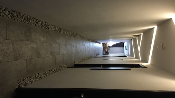 Un pasillo con paredes de piedra y un banco de madera.