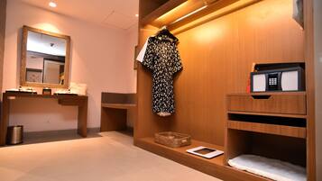 Un baño moderno con tocador de madera, un espejo, una bata, un microondas y una pequeña cesta.