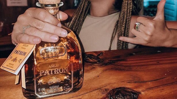 Eine Person hält eine Tequile-Flasche mit einem Korken.