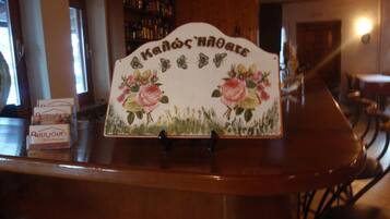 A wooden counter with a decorative sign featuring floral designs and text.