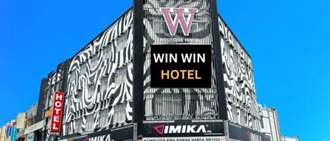 A building with a large 'W' logo and 'WIN WIN HOTEL' signage.