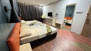 Habitación de hotel con dos camas, un escritorio, un espejo y un televisor.