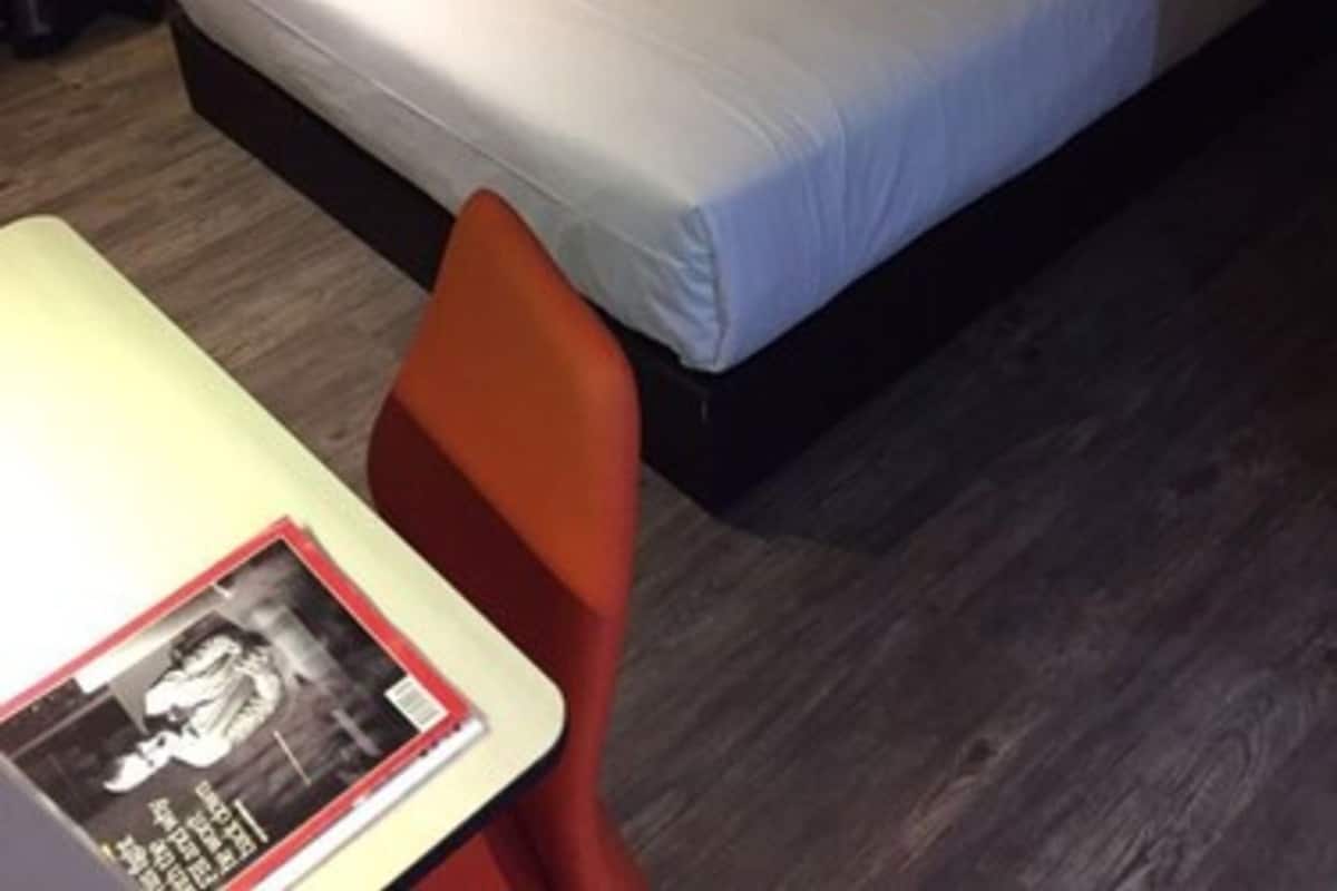 Una habitación de hotel con una cama, una mesa y una silla.