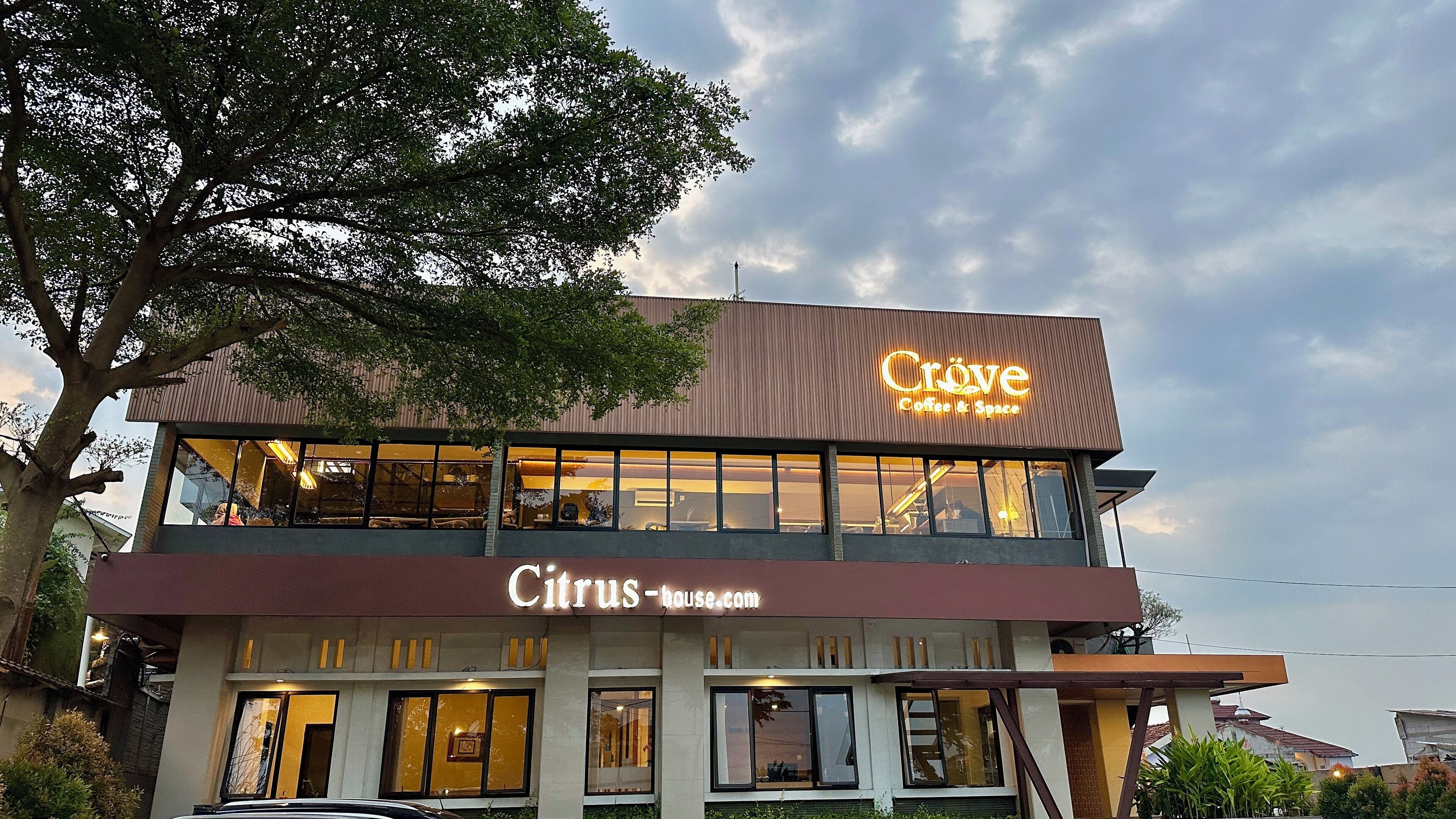Un edificio de dos plantas con un letrero que dice 'Citrus-house.com' y 'Cröve Coffee & Space'.