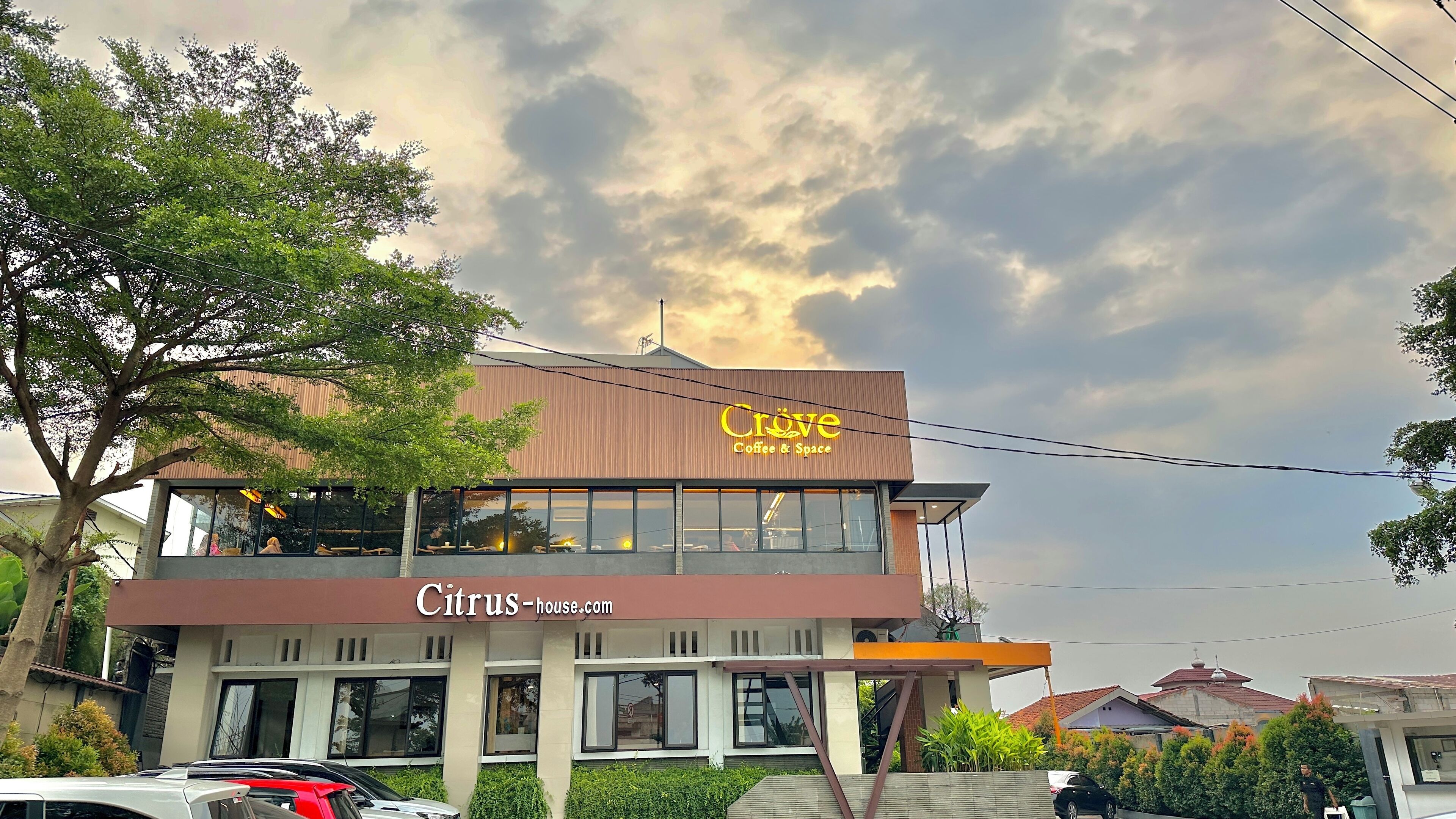 Un edificio de dos pisos con un letrero que dice "Citrus-house.com" y "Crove Coffee & Space".
