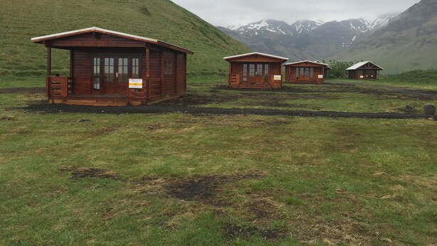 Three wooden cabins with a mountain backdrop. - North Star Cottage (Rangárþing eystra)