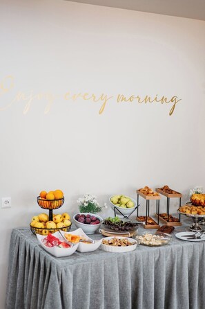 A breakfast buffet with various fruits, pastries, and a decorative sign saying 'Enjoy every morning.' - Hotel Mediterrane (Sarandë)