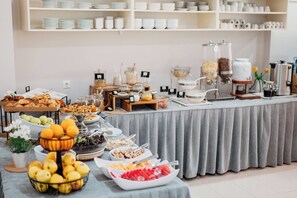 Ein reichhaltiges Buffet mit verschiedenen Speisen und einer Kaffeestation.
