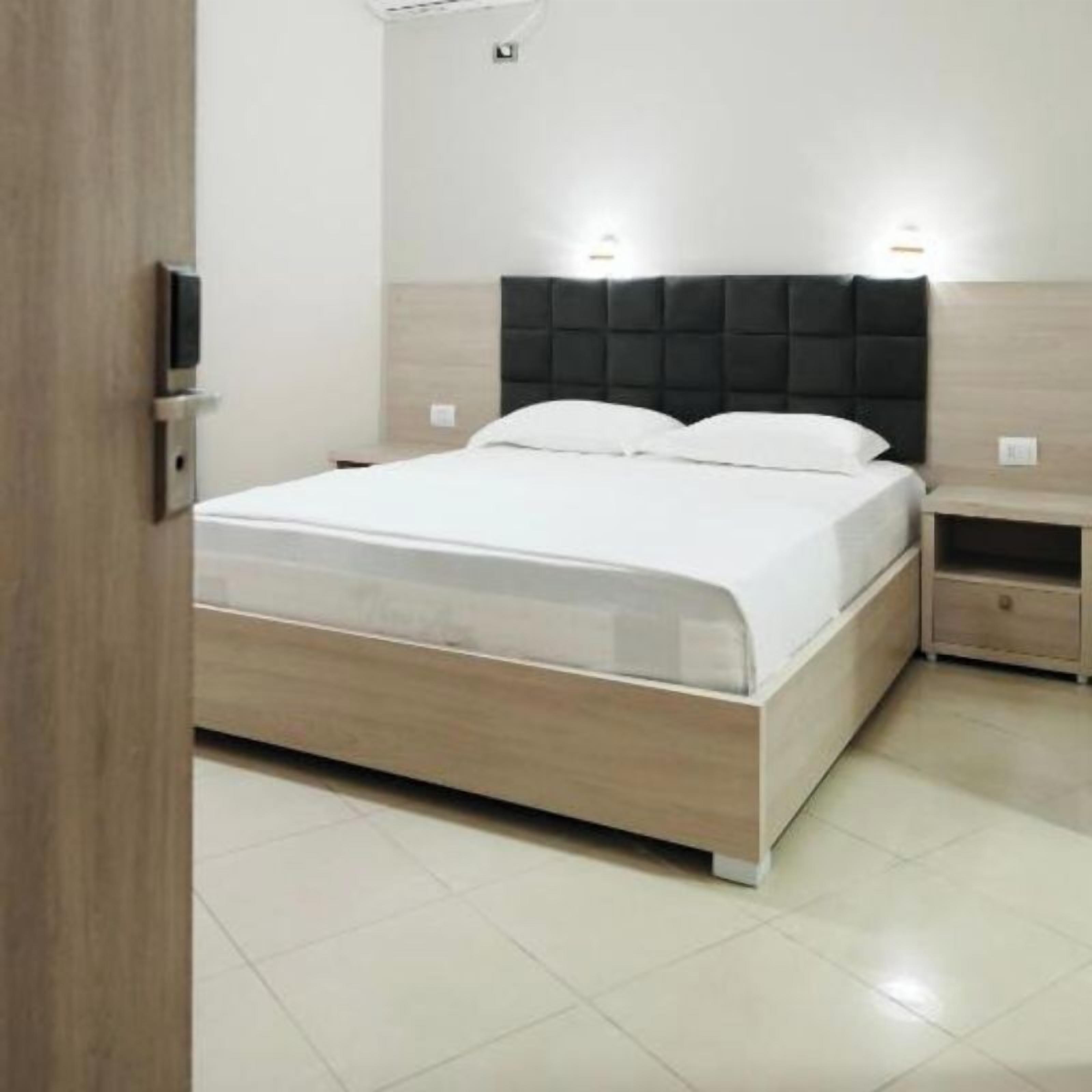 A modern bedroom with a bed, bedside tables, and a nightstand.
