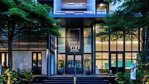 Un edificio moderno con un gran letrero que dice "CROSS VIBE BANGKOK SUKHUMVIT".