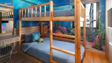 Cozy children's room with a bunk bed and vibrant underwater mural, perfect for kids to play and study.