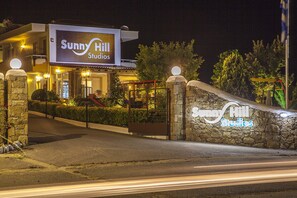 A building with a sign reading "Sunny Hill Studios" at night. - Sunny Hill Hotel (Kassandra)