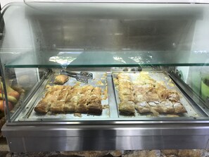 A food display case with pastries and a pair of tongs. - Sunny Hill Hotel (Kassandra)