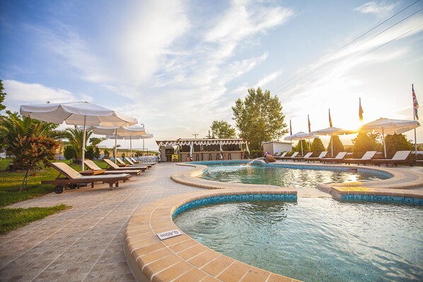 室外游泳池，池畔遮阳伞，日光浴躺椅