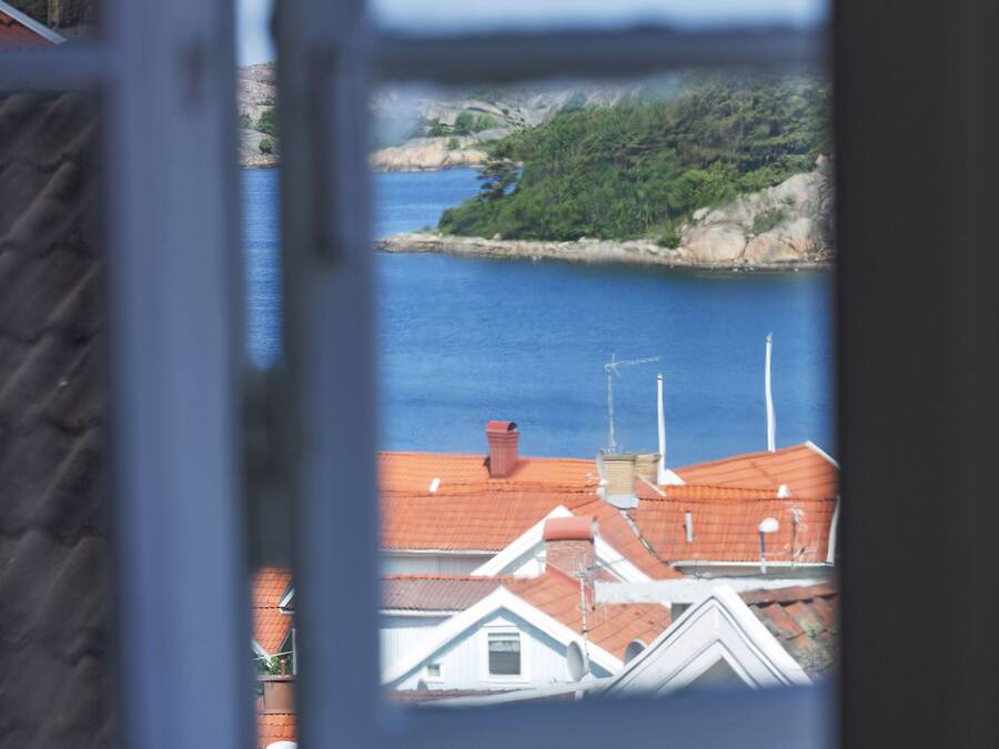 A view through a window of a coastal area with buildings and a body of water.