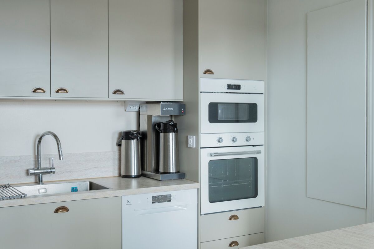 A modern kitchen with a built-in dishwasher, double oven, and stainless steel appliances.
