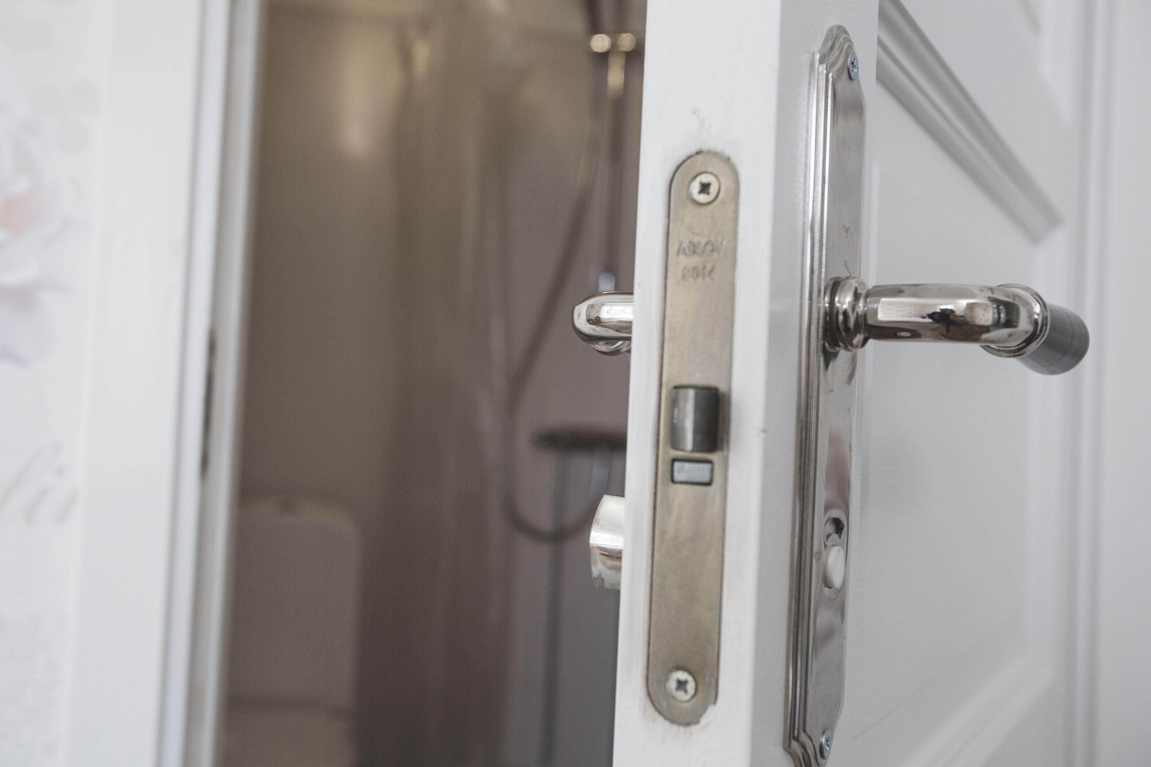 A bathroom door with a towel rack and a towel dispenser.