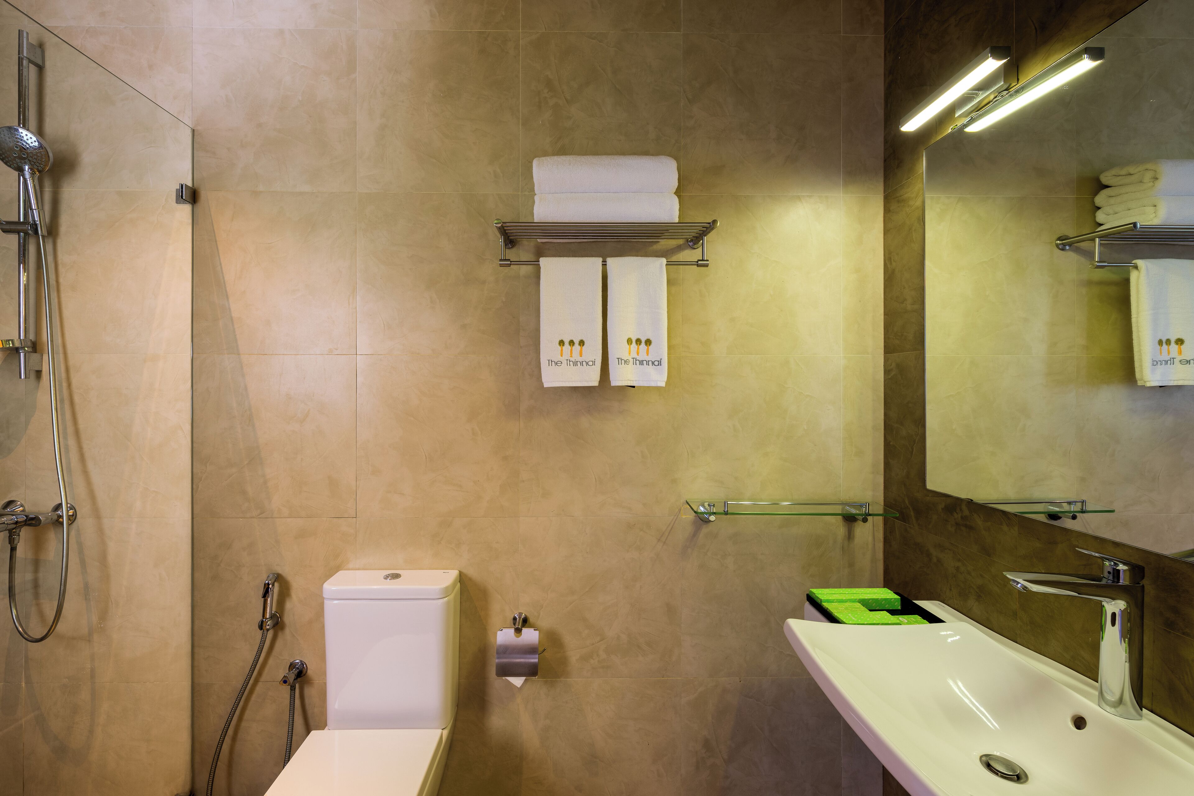 A modern bathroom with a shower, toilet, sink, and towel rack.