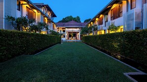 A hotel with a central courtyard, symmetrical design, and well-maintained hedges.