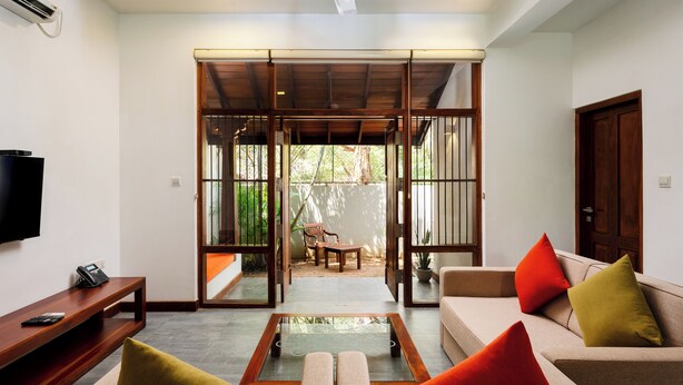 A living room with a sofa, a coffee table, a TV, and a wooden bench.