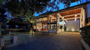 A modern two-story building with a covered outdoor area, a staircase, and a dining table. - The Thinnai Hotel (Jaffna)