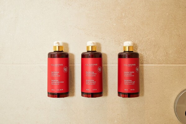 Three Clarins Paris skincare products on a tiled wall. - Hotel FRANQ (Antwerp)