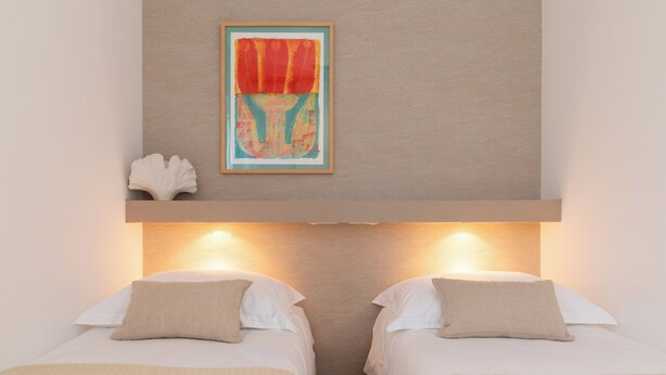 A hotel room with two beds, a framed artwork above the beds, and a wall-mounted light fixture. - Villa Lavanda Deluxe (Rogoznica)