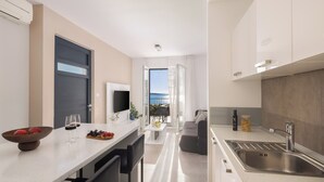 A modern kitchen with a dining area, a built-in TV, and a view to the outside. - Villa Lavanda Deluxe (Rogoznica)