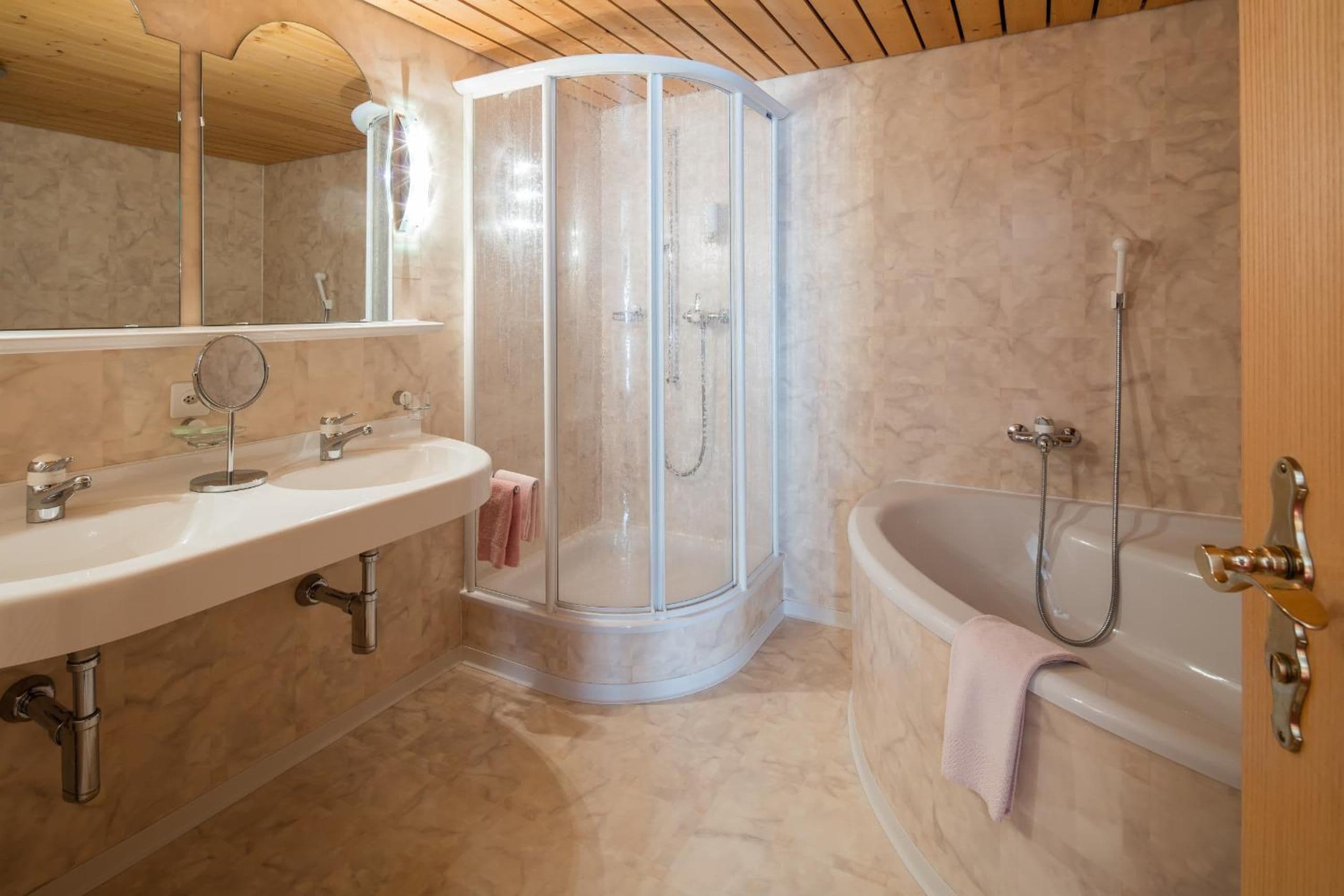 Un bagno moderno con doccia d'angolo, vasca freestanding e mobile vanità con specchio.