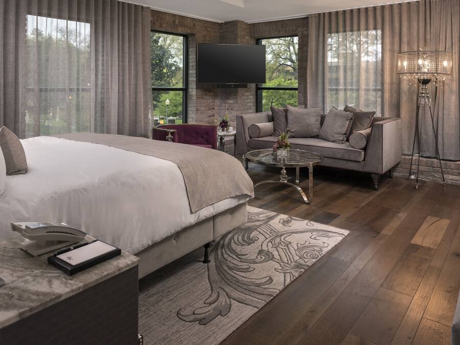 Ein modernes Schlafzimmer mit einem großen Bett, einer Couch, einem Couchtisch und einem Fernseher.