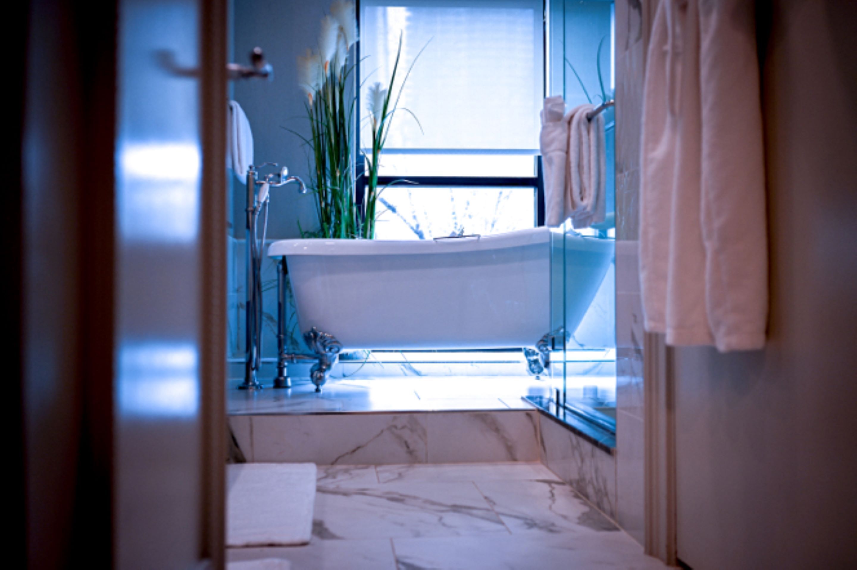 Un baño con bañera independiente, cabina de ducha de cristal y ventana que proporciona luz natural.