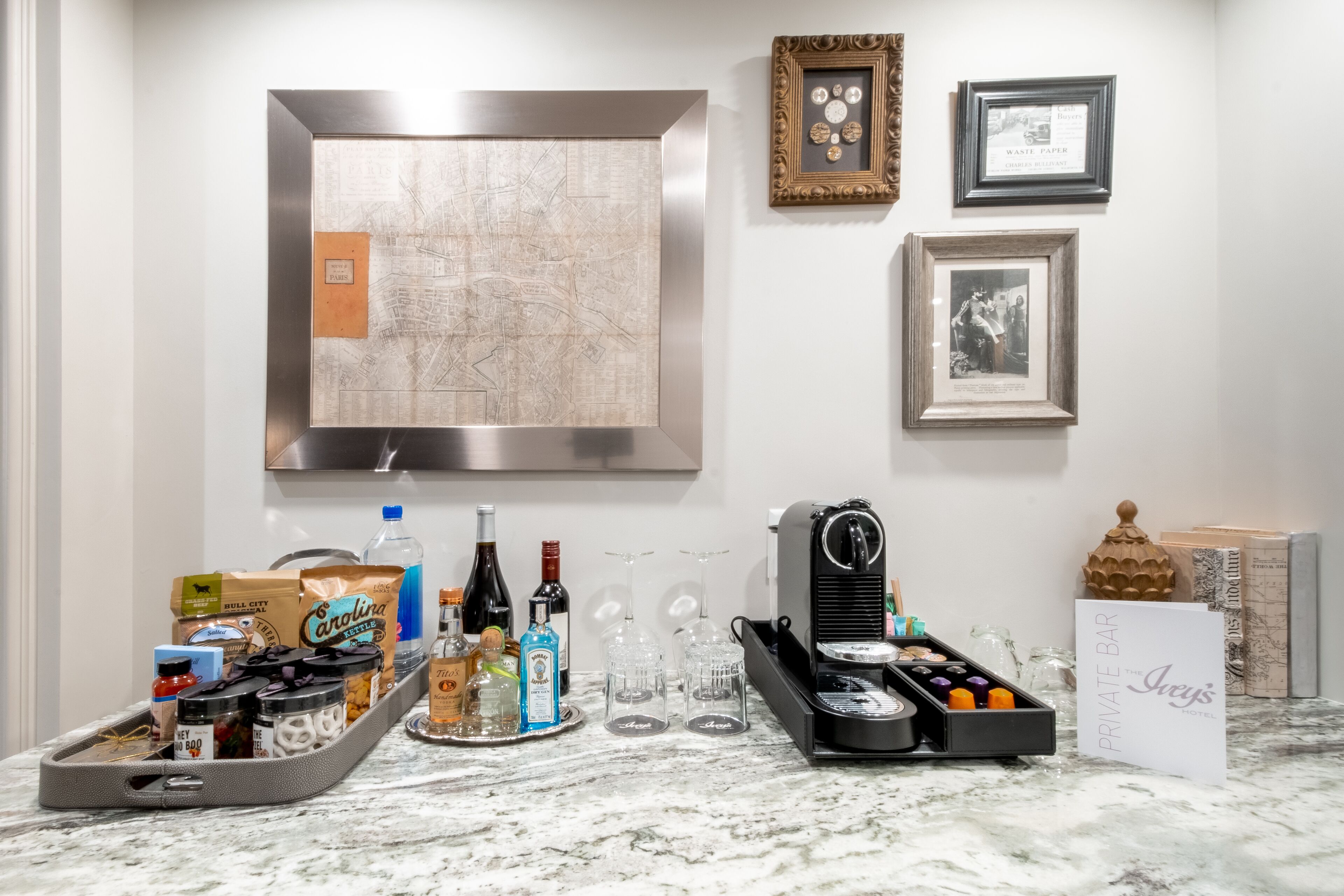 A kitchen counter with a coffee machine, wine bottles, and a tray of snacks.